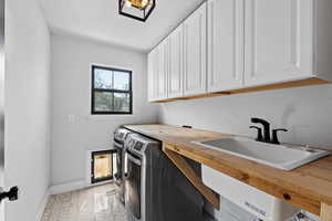 Laundry room featuring a textured ceiling, washer and dryer, and cabinet space