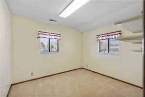 Unfurnished room featuring carpet floors and lofted ceiling