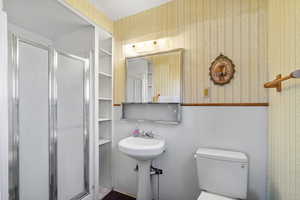 Bathroom with wallpapered walls and a shower stall