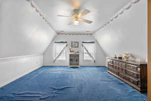 Additional living space featuring lofted ceiling and carpet floors