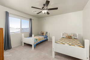 Bedroom featuring light colored carpet and a ceiling fan