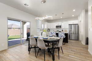 Dining room featuring light wood-type flooring, plenty of natural light, and recessed lighting