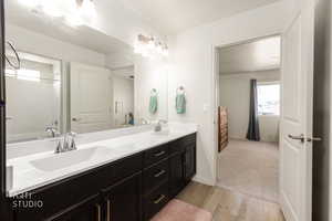 Full bathroom featuring double vanity, light wood finished floors, and shower / bath combination