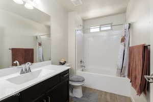 Full bath featuring light wood-style floors, vanity, and shower / bathtub combination with curtain