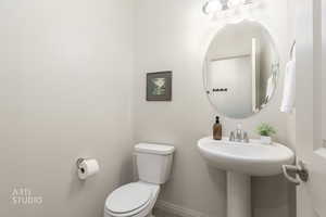Half bath with toilet and baseboards