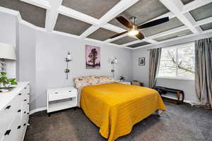 Master Bedroom with dark carpet, coffered ceiling, beam ceiling, crown molding, and ceiling fan