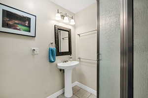 Bathroom with light tile patterned floors and a shower stall