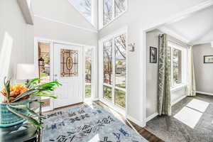 Foyer entrance with wood finished floors and a towering ceiling