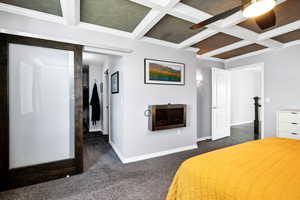 Master Bedroom with dark carpet, coffered ceiling, beam ceiling, crown molding, and ceiling fan