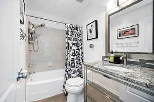 Bathroom with shower / bathtub combination with curtain and vanity