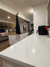 Kitchen with white cabinetry, appliances with stainless steel finishes, a textured ceiling, light stone counters, and open floor plan