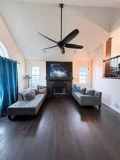 Living area with lofted ceiling, dark wood-type flooring, and a fireplace