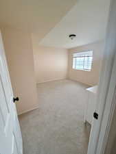 Unfurnished room with light colored carpet and baseboards