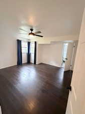 Spare room featuring dark wood finished floors, a textured ceiling, and a ceiling fan