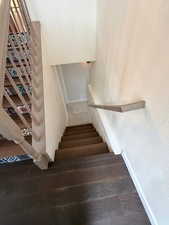 Staircase with baseboards and wood finished floors