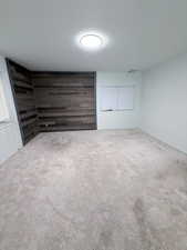 Unfurnished room with carpet and wood walls