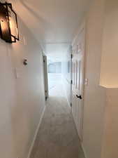 Corridor featuring carpet flooring and baseboards