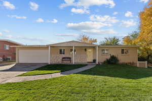 Single story home featuring covered porch, brick siding, concrete driveway, and a front yard
