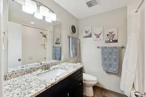 Full bath with vanity and wood finished floors