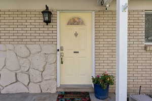 Property entrance featuring brick siding