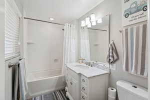 Bathroom with shower / tub combo with curtain and vanity