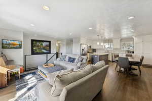 Living area with dark wood-type flooring and recessed lighting
