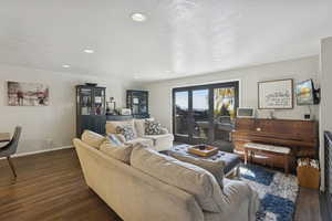 Living room featuring dark wood finished floors, recessed lighting, and a textured ceiling