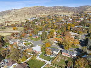 Aerial view of property and surrounding area with mountains and nearby suburban area