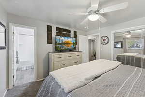 Bedroom with dark carpet, a closet, ceiling fan, and connected bathroom