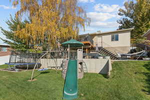 View of jungle gym featuring stairway, a trampoline, and a patio