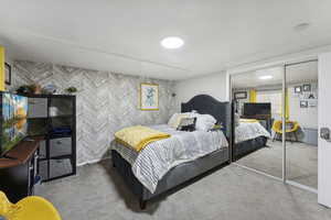 Bedroom with carpet floors, a closet, and wallpapered walls