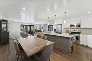 Dining area featuring a textured ceiling, dark wood-style flooring, and recessed lighting