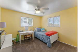 Bedroom featuring dark colored carpet and a ceiling fan