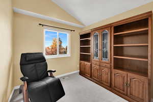 Sitting room featuring vaulted ceiling and light carpet
