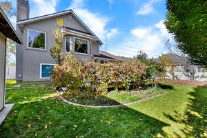 Back of house featuring stucco siding and a chimney