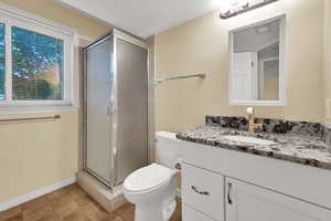 Bathroom featuring a stall shower, vanity, and light tile patterned flooring