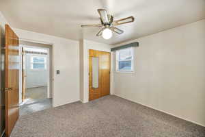 Unfurnished bedroom featuring carpet, multiple windows, a closet, and a ceiling fan