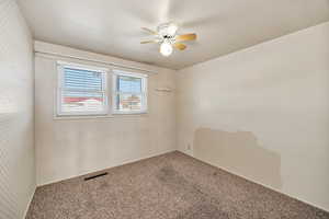 Spare room with carpet flooring, a ceiling fan, and wallpapered walls