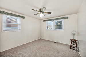 Carpeted empty room featuring ceiling fan