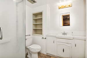 Bathroom featuring vanity, built in features, and a shower