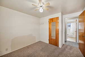 Unfurnished bedroom featuring carpet floors and ceiling fan
