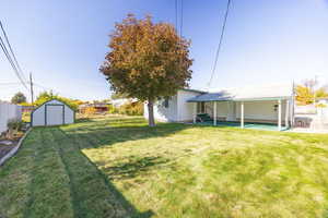 View of yard featuring a covered patio area and an outdoor structure