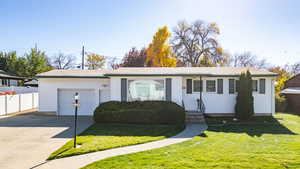 Home featuring an attached garage, concrete driveway, and a chimney
