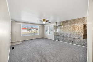 Unfurnished living room with carpet and a ceiling fan