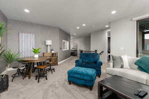 Living room featuring wallpapered walls, recessed lighting, carpet, and a textured ceiling