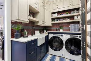 Washroom with separate washer and dryer, farm sink, and cabinet space