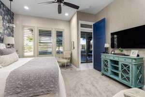 Primary bedroom featuring wallpapered walls, light colored carpet, recessed lighting, ceiling fan, and access to outside