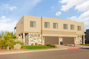 View of front of property featuring stucco siding, concrete driveway, and a garage