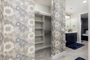 Bathroom with vanity, ensuite bathroom, a closet, light tile patterned floors, and recessed lighting
