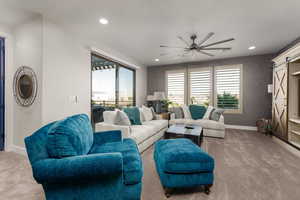 Living area featuring a sliding door to balcony, light colored carpet, ceiling fan, healthy amount of natural light, and recessed lighting